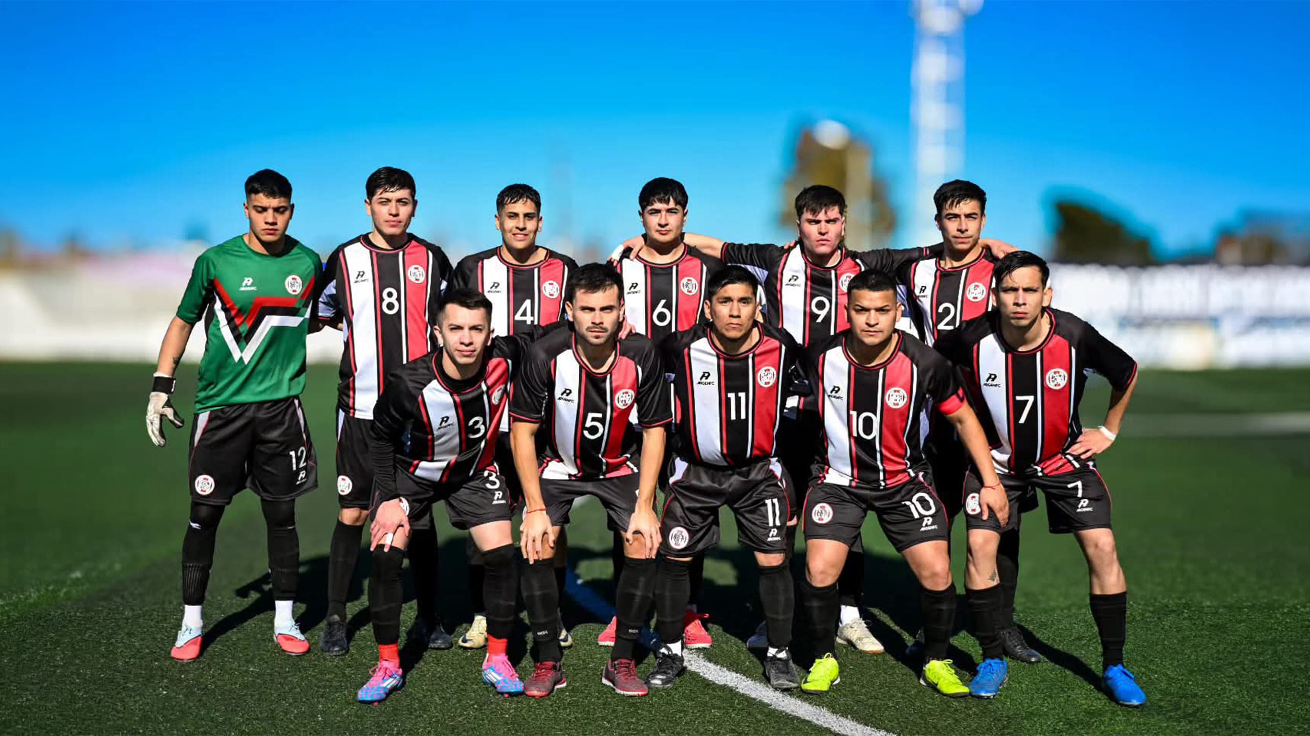 Plantel de un club posando en la cancha con la camiseta y el short del equipo